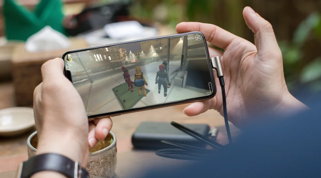 Photo d'une personne jouant à CinQ sur son téléphone portable.